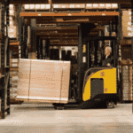 A Yale narrow aisle forklift transporting goods between pallet racks in a warehouse.