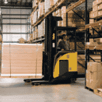 A Yale narrow aisle forklift transporting goods between pallet racks in a warehouse.