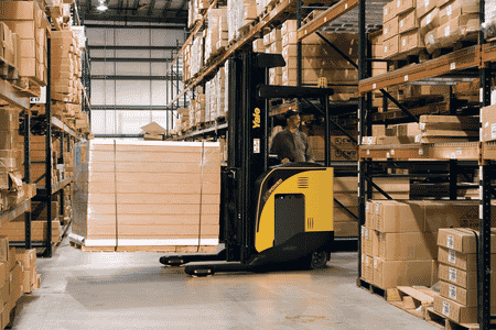 A Yale narrow aisle forklift transporting goods between pallet racks in a warehouse.