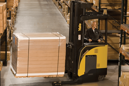 A Yale narrow aisle forklift transporting goods between pallet racks in a warehouse.