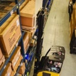 A reach truck getting goods from a shelf in a warehouse.