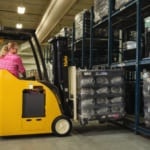 A Yale forklift picking a pallet of goods from a shelf in a warehouse.
